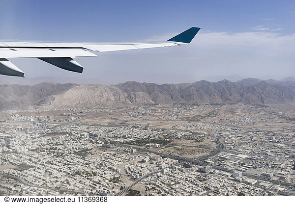 Cropped image of airplane flying above city  Maskat  Oman