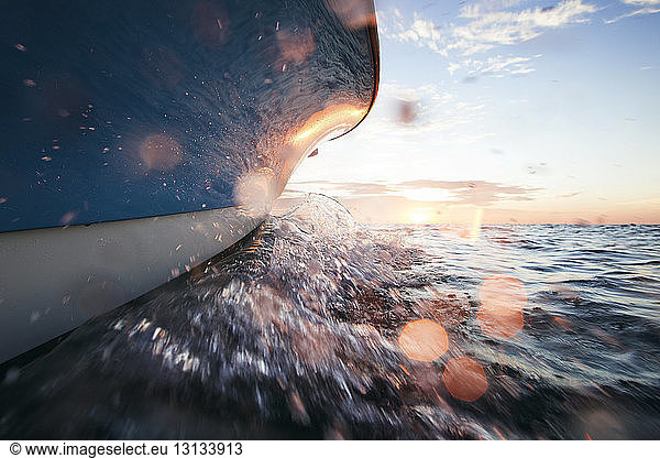 Cropped image of boat splashing water on sea