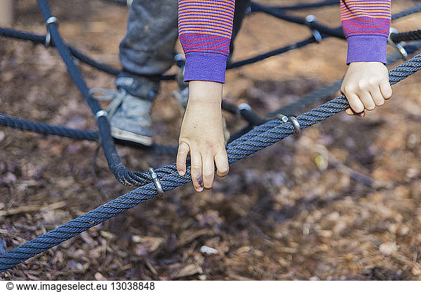 Cropped image of boy playing on jungle gym