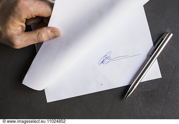 Cropped image of businessman holding document with signature