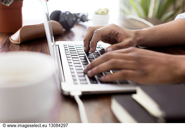Cropped image of creative businessman using laptop at desk