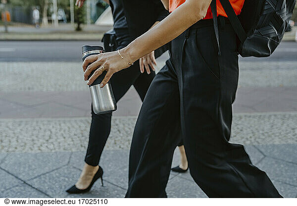 Cropped image of female entrepreneur walking on street