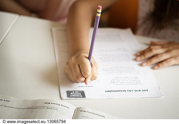 Cropped image of girl studying at table