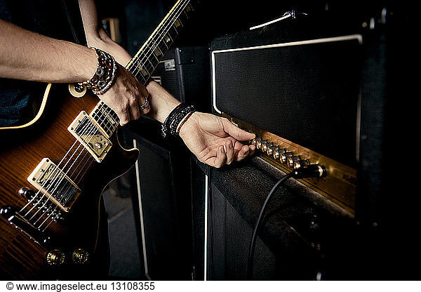 Cropped image of guitarist playing music at studio
