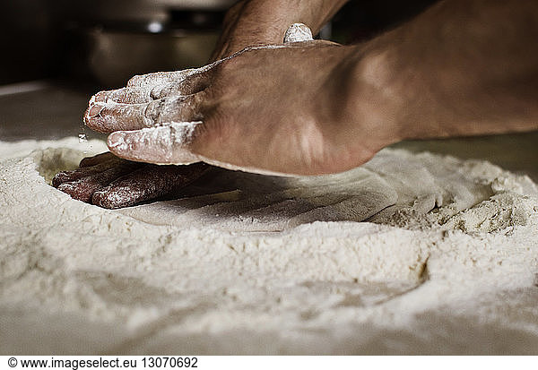 Cropped image of hands kneading dough