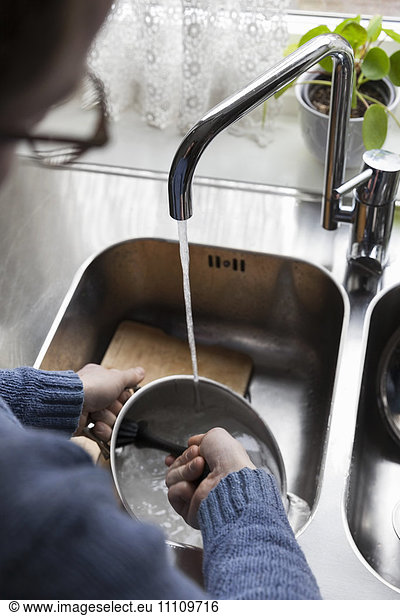 Cropped image of man washing utensils at home