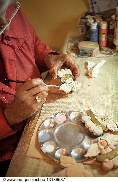 Cropped image of manual worker making clock at workshop