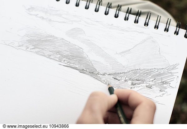 Cropped image of person sketching on paper