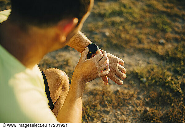 Cropped image of sportsman checking time on wristwatch