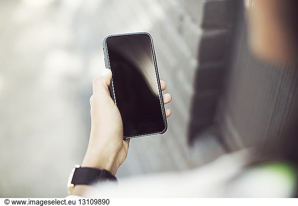 Cropped image of woman holding smartphone