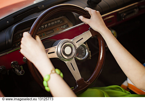 Cropped image of woman holding steering wheel