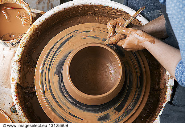 Cropped image of woman molding shape on pottery wheel