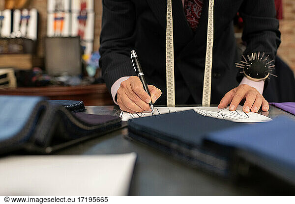 Cropped male dressmaker creating sketch