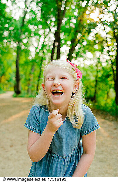 Cropped shot of a young girl laughing in the middle of a trail