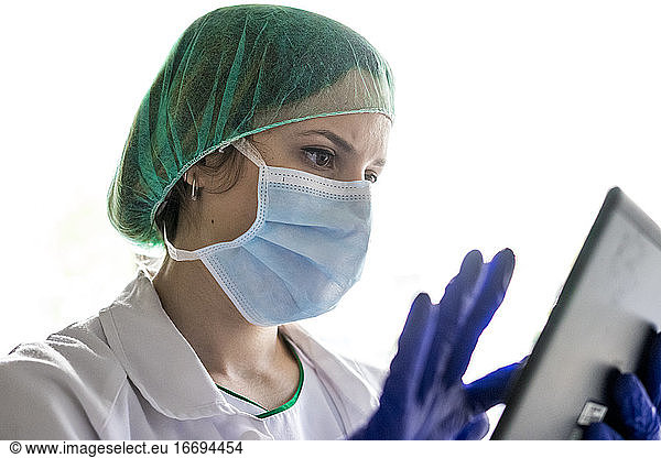 Cropped shot of an unrecognizable female nurse using a digital tablet while standing in a hospitaCropped shot of an unrecognizable female nurse using a digital tablet