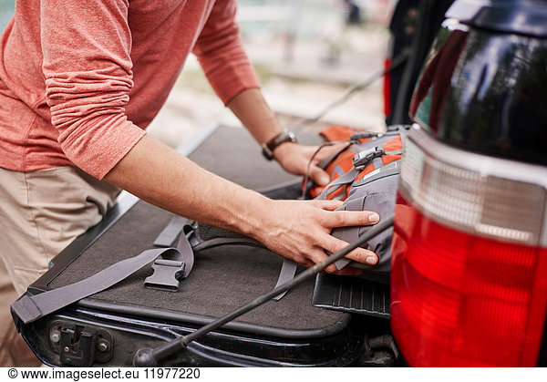 Cropped view of man putting rucksack in car boot  Krakow  Malopolskie  Poland  Europe