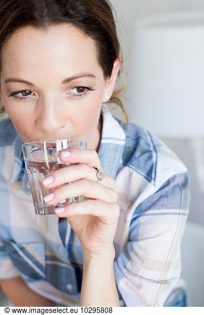 Cropped view of mature woman drinking a glass of water