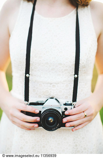 Cropped view of woman holding camera