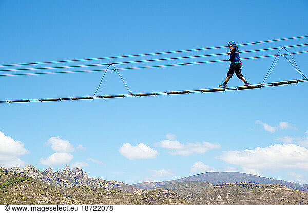 Crossing a Tibetan bridge during via ferrata climbing in Spain