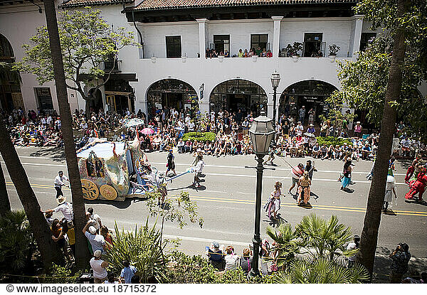 Crowds enjoy an annual parade in Santa Barbara. The parade features extravagant floats and costumes.