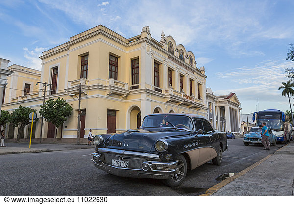 Cuba  Cienfuegos  parking American vintage car with Tomas Terry Theatre in the background