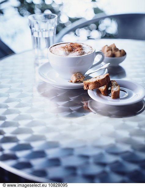 Cup of cappuccino  biscotti on table