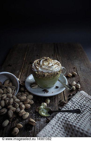 Cup of pudding with cream topped with pistachio bits