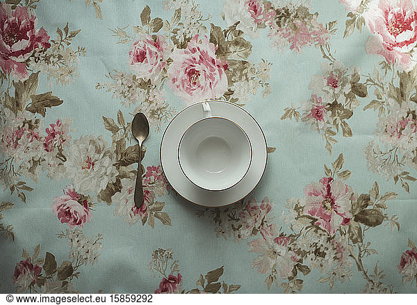 cup of tea and spoon on a flowered background