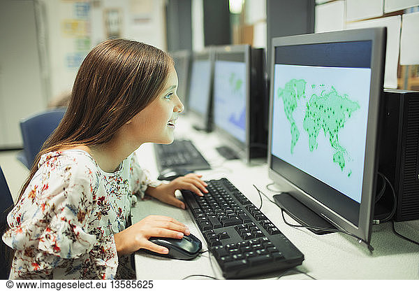 Curious junior high school girl student looking at map on computer in classroom