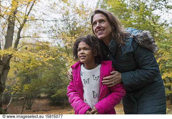Curious mother and daughter in autumn woods