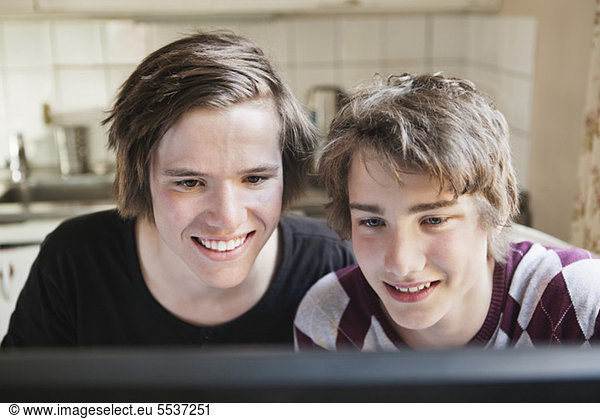 Curious teenage boys looking at desktop