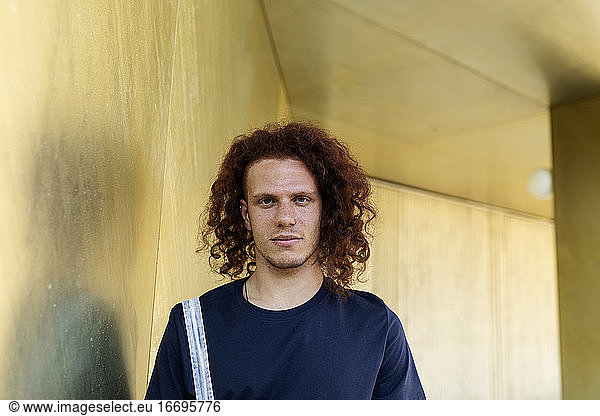 Curly red hair men portrait at golden background