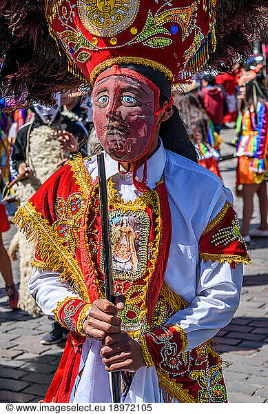 Cusco  a cultural fiesta  people dressed in traditional colourful costumes with masks and hats with feathers.