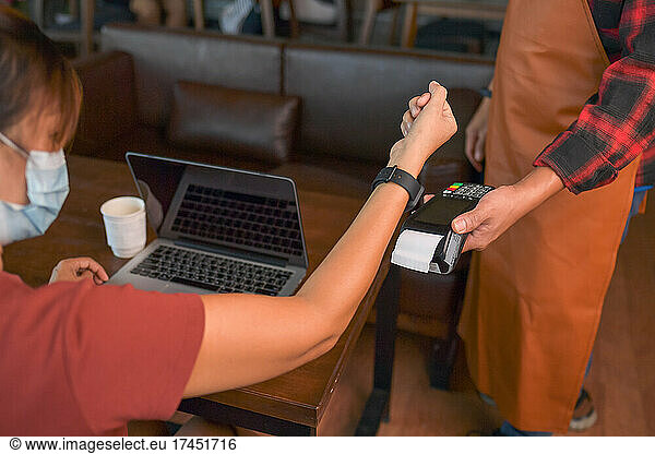 Customer making wireless or contactless payment using smartwatch