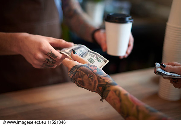 Customer paying for her coffee with cash