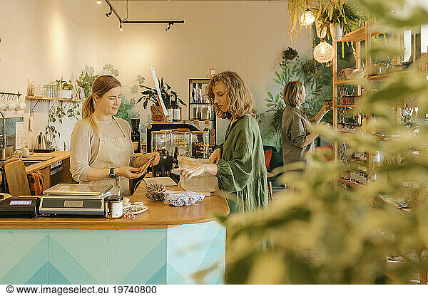 Customer paying to owner at checkout counter in store