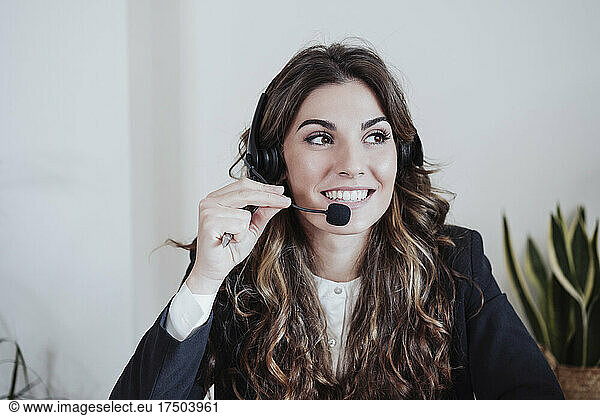 Customer service representative talking on headset at office