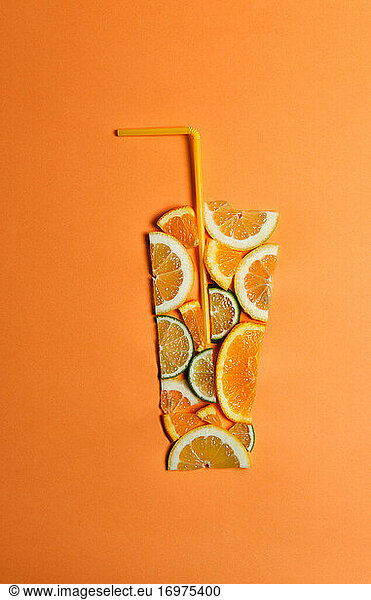 cut fruits on an orange background imitating a glass