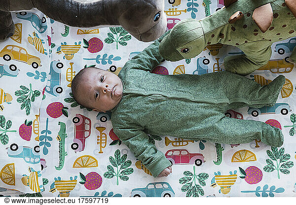Cute baby boy lying on bed in bedroom