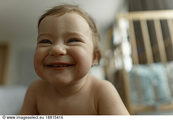 Cute baby girl laughing in bedroom