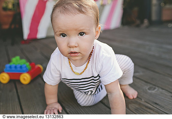 Cute baby girl on floorboard at birthday party