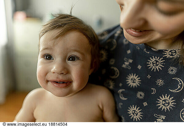 Cute baby girl with mother in bedroom