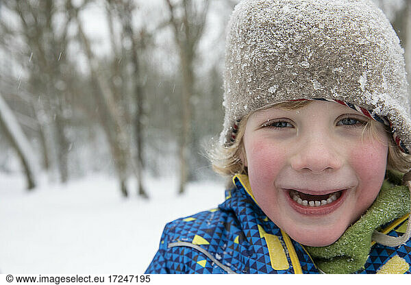 Cute boy freezing in snow during winter