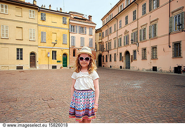 Cute child standing on medieval square in Tuscany
