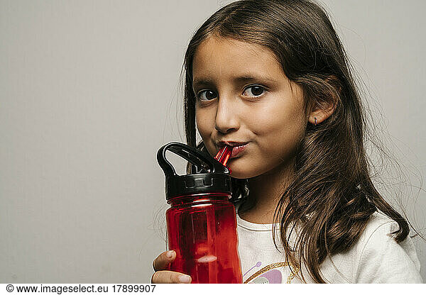 Cute girl drinking water from bottle
