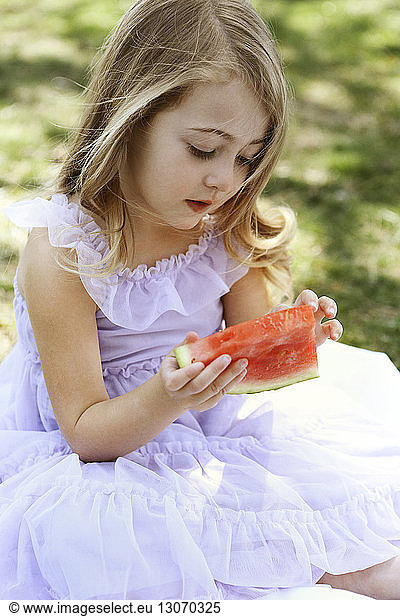 Cute girl eating watermelon in backyard