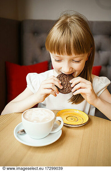 cute girl eats chocolate chip cookies