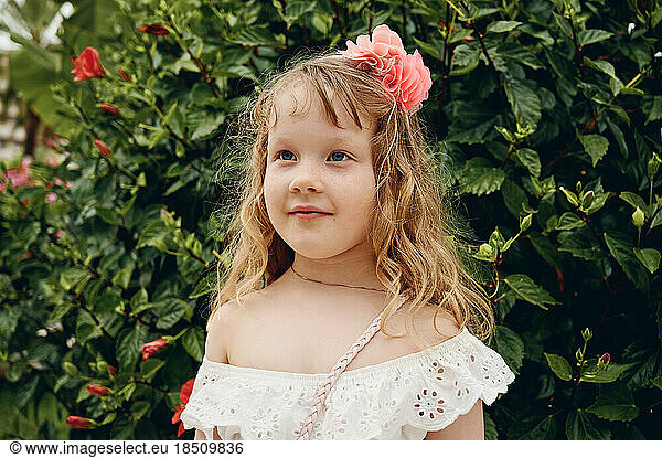 Cute girl near blooming shrub