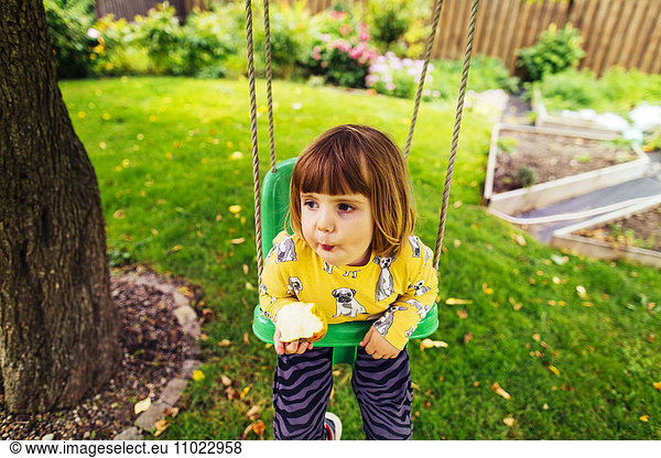 Cute girl swinging in backyard