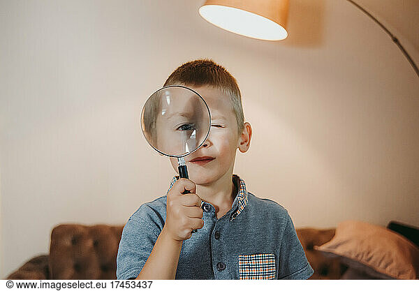 Cute little boy holding a magnifying glass